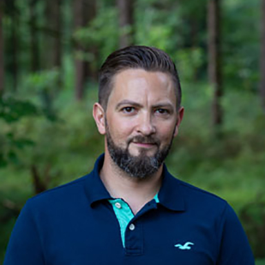 WEBgarten - Webdesign - Braunau | Porträt von Markus Skiba, dem kreativen Kopf und Inhaber von WEBgarten, vor einem natürlichen Waldhintergrund.